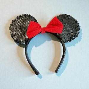 Disney Minnie Mouse sequined ear headband with a red bow.